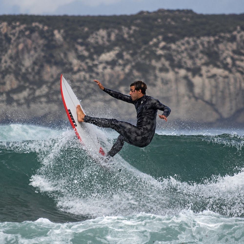 Surfista haciendo una maniobra en una ola